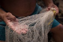 Partie médiane du pêcheur tenant un filet de pêche — Photo de stock