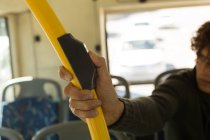 Homem pressionando botão no poste enquanto viaja no ônibus — Fotografia de Stock