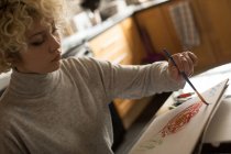 Giovane donna che colora uno schizzo a casa — Foto stock