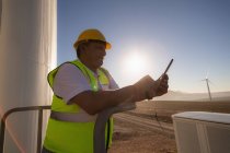 Engineer using a digital tablet at entrance of a wind mill at a wind farm — Stock Photo