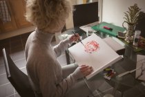 Jeune femme colorier un croquis à la maison — Photo de stock