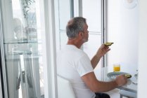 Зрілою людиною в будинку маючи сніданок — стокове фото