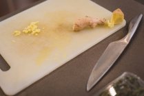 Gros plan de la planche à découper avec couteau et gingembre dans la cuisine à la maison — Photo de stock