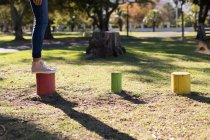 Woman stepping on colorful stumps in the park on a sunny day — Stock Photo