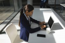Empresária concentrada usando laptop no escritório — Fotografia de Stock