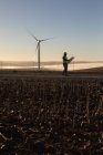 Ingénieur tenant un terrain aménagé dans un parc éolien — Photo de stock