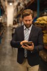 Male manager using digital tablet in warehouse — Stock Photo
