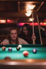 Coppia che gioca a biliardo nel night club — Foto stock