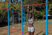 Atleta donna determinata che fa pull up sulle sbarre — Foto stock