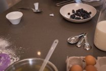 Чорниця з молоком і посудом на кухонній стільниці вдома — стокове фото