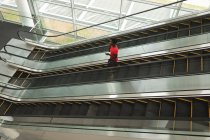 Geschäftsfrau telefoniert auf Rolltreppe im Büro — Stockfoto