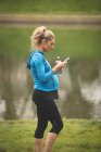 Donna incinta che utilizza il telefono cellulare nel parco — Foto stock