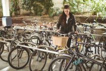 Bella donna parcheggio sua bicicletta — Foto stock