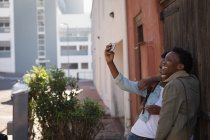 Twins siblings taking selfie with mobile phone in city street — Stock Photo