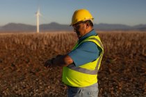 Engineer using a smart watch at a wind farm — Stock Photo
