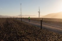 Rückansicht eines Ingenieurs, der an einem Windpark spaziert — Stockfoto