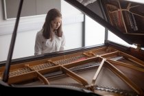 Adorable colegiala tocando piano en la escuela de música - foto de stock
