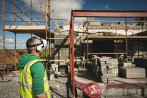 Engineer with VR headset looking at the construction site on a sunny day — Stock Photo