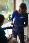 Physiotherapeut legt Seniorin zu Hause Handgelenkstütze an — Stockfoto