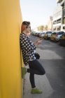 Молода жінка використовує мобільний телефон на тротуарі — стокове фото