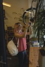 Jeune femme photographiant un vélo au café — Photo de stock