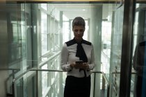 Empresária usando seu telefone celular no elevador do escritório — Fotografia de Stock