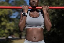 Parte centrale dell'atleta donna determinata che si allena sulle sbarre — Foto stock