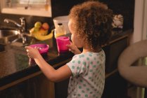 Ребенок ест овес и пьет на кухне дома — стоковое фото