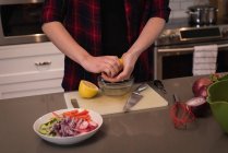 Frau quetscht Zitrone in Küche zu Hause — Stockfoto
