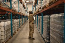 Male worker checking stocks in warehouse — Stock Photo