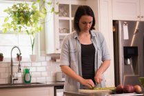 Femme coupe légumes dans la cuisine à la maison — Photo de stock