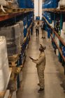 Работник мужского пола проверяет акции на складе — стоковое фото