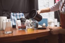 Femme photographe versant un produit chimique en fiole au studio photo — Photo de stock