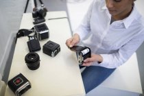 Fotógrafo fêmea removendo bobina da câmera digital no estúdio de fotos — Fotografia de Stock