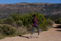 Atleta donna determinata che corre nella foresta — Foto stock