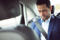 Smart businessman travelling in a car — Stock Photo