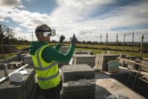 Инженер, испытывающий VR гарнитуру на строительной площадке в солнечный день — стоковое фото