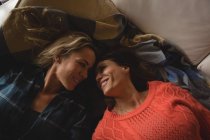 Pareja lesbiana relajándose en la sala de estar en casa - foto de stock