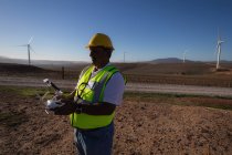 Ingegnere che gestisce un drone in un parco eolico — Foto stock