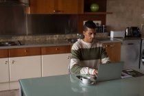Mann benutzt Laptop auf Esstisch zu Hause — Stockfoto