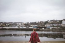 Человек, сидящий в порту и оглядывающийся — стоковое фото