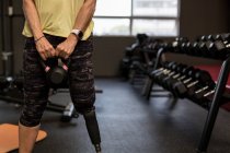 Partie médiane de la femme handicapée faisant de l'exercice sur la machine dans la salle de gym — Photo de stock