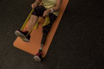 Mulher com deficiência se exercitando com banda de resistência no ginásio — Fotografia de Stock