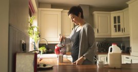 Schwangere bereitet zu Hause in der Küche Kaffee zu — Stockfoto
