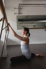 Young woman stretching on the barre at the gym — Stock Photo