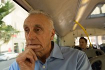 Pensando en el hombre mayor que viaja en el autobús - foto de stock