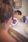 Mulher bonita olhando no espelho no banheiro — Fotografia de Stock
