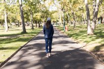 Visão traseira da mulher de pé na estrada no parque — Fotografia de Stock