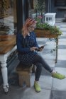 Jeune femme utilisant une tablette à l'extérieur du café — Photo de stock