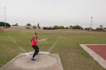 Sportlerin übt Kugelstoßen an Sportstätte — Stockfoto
